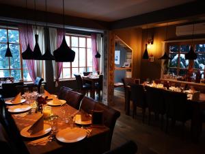 a dining room with tables and chairs and windows at Pensiune Restaurant La Cassa in Vişeu de Sus