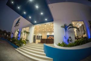 a building with stairs and palm trees in front of it at Hotel Santa Cruz Juchitan in Juchitán de Zaragoza