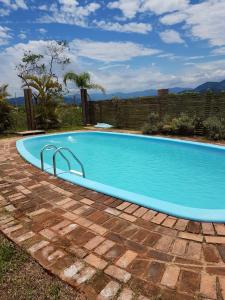 uma grande piscina azul num quintal em Villa Suzana em Praia do Rosa