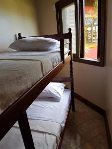 a pair of bunk beds in a room with a window at Villa Suzana in Praia do Rosa