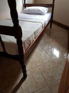 a bed sitting on top of a tiled floor at Villa Suzana in Praia do Rosa