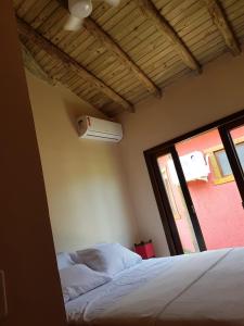 a bedroom with a bed and a window at Villa Suzana in Praia do Rosa