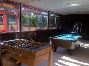 two pool tables in a room with windows at Hostal Madrid Paris in Buitrago del Lozoya