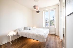 biała sypialnia z łóżkiem i oknem w obiekcie Creative Design House Golf & SPA w mieście Pozzolengo