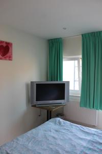 Schlafzimmer mit einem Flachbild-TV und einem Bett in der Unterkunft Logie Rotem in Dilsen-Stokkem