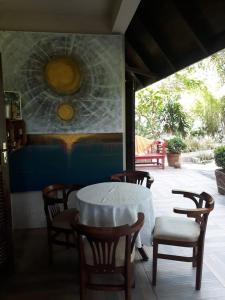 una mesa y sillas en una habitación con una pintura en Apto térreo com jardim - Praia do Estaleiro- Balneário Camboriu, en Balneário Camboriú