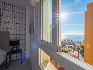 a bedroom with a window with a view of the ocean at MALAGUETA SEA VIEW - PREMIUM APARTMENT in Málaga