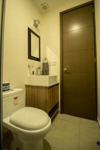 Un baño con inodoro, lavabo y puerta. en NIZA FIVE Luxury Beach Apartments, en Puerto Vallarta
