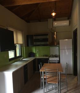a kitchen with a table and chairs and a refrigerator at Archontiko Kirfis in Desfina in Dhesfína