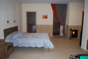 1 dormitorio con 1 cama y chimenea en Jūrmalas Priedes, en Apšuciems