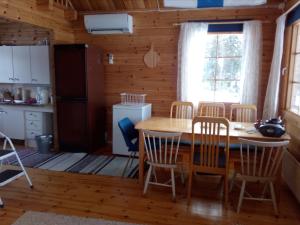 a kitchen and dining room with a table and chairs at Tarinatupa Simojärvi in Impiö