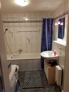 uma casa de banho com uma banheira e um lavatório e uma banheira em Appartmenthaus Gingst em Gingst