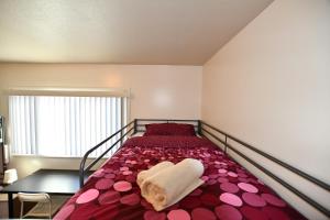 a bedroom with a bed with a towel on it at Hostel Style Shared Room in Daly City