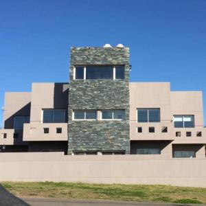 un edificio alto con una fachada de piedra en DEPARTAMENTOS SERENA II en Mar del Plata