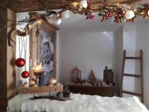 Un dormitorio con una cama con adornos navideños. en Majon de la nona, en Pozza di Fassa