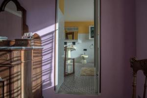 a bathroom with a door open to a room with a kitchen at l'Oca Mannara in Ameno
