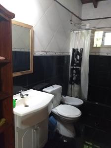 un bagno con un water bianco e un lavandino di La Tribu a Paso de la Patria Altre 24 foto