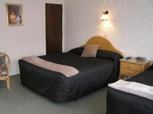 Tempat tidur dalam kamar di Coachman Motel