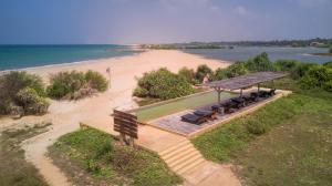 uma vista superior para uma praia com uma mesa de piquenique e bancos em Elements Beach & Nature Resort em Kalpitiya