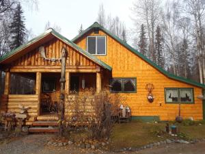 a log cabin with a green roof at Alaska's Northland Inn in Trapper Creek