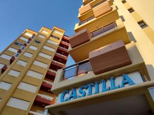 Un edificio alto con un cartel. en Hotel Castilla en Villa Gesell