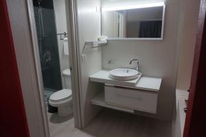 a bathroom with a sink and a toilet and a mirror at Travelodge by Wyndham Orlando at Heart of International Drive in Orlando