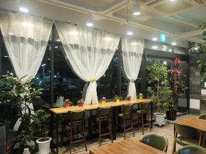 a restaurant with a long table with chairs and plants at Ehwa In Myeongdong in Seoul +114 photos