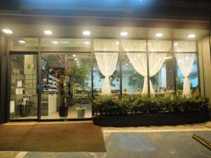 eine Ladefront mit einem Fenster mit Vorhängen und Pflanzen in der Unterkunft Ehwa In Myeongdong in Seoul