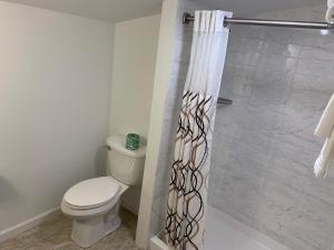 
a bathroom with a toilet and a shower stall at Four Winds Country Motel in Manchester
