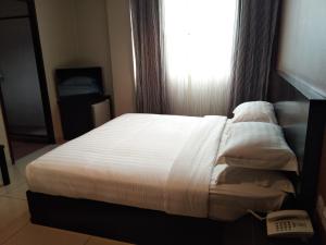 Postel nebo postele na pokoji v ubytování Kinabalu Daya Hotel