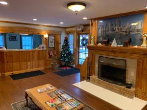 a living room with a fireplace and a christmas tree at Four Winds Country Motel in Manchester