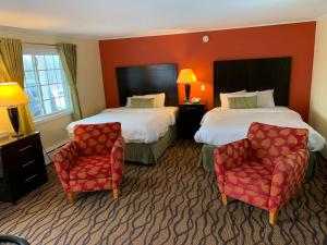 a hotel room with two beds and two chairs at Four Winds Country Motel in Manchester +53 photos