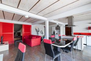 a living room with a dining table and a red couch at Villa Tangor in Petite Île