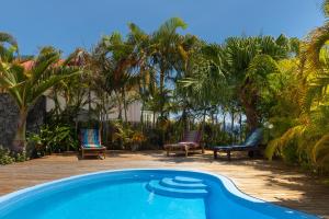 una piscina con 2 sillas y avisor en Villa Tangor en Petite Île