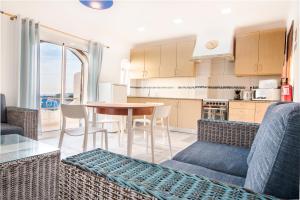 a kitchen and living room with a table and chairs at Tonel Apartamentos Turisticos in Sagres