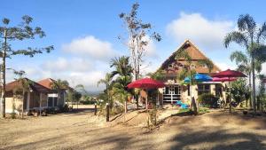 a house with red umbrellas in front of it at วังผา ชาเล่ต์ รีสอร์ท in Ban Fai Mun