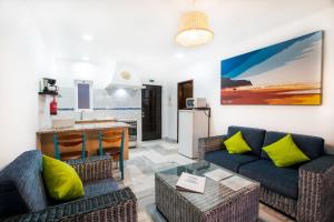 a living room with a couch and a kitchen at Tonel Apartamentos Turisticos in Sagres