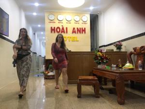 two women are standing in a room with a sign at Hotel Hoai Anh in Vung Tau