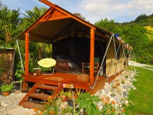 Pohara的住宿－Omarama Oasis - Permaculture Glamping，花园内带长凳的凉亭