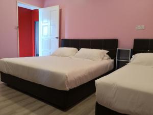 Duas camas num quarto com paredes cor-de-rosa em I Love U BnB 爱乐游民宿 步行5 分钟到码头 em Semporna