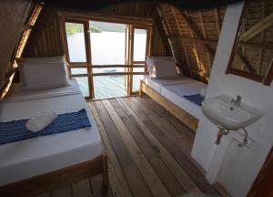 a bathroom with two beds and a sink in a boat at Borac Bay Bungalows Hotel and Resort in Coron