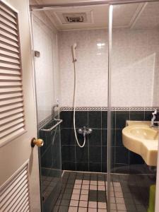 y baño con ducha y lavamanos. en Little Paradise Inn en Hengchun