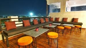 Un restaurante con mesas y sillas en un balcón. en THC Backpackers jodhpur, en Jodhpur