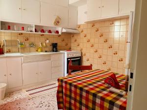 a kitchen with a table with a checkered table cloth at Small Apartment in Markopoulo center in Markopoulo