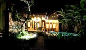 una casa con una piscina delante de ella por la noche en Merta House Jasan Village, en Tegalalang