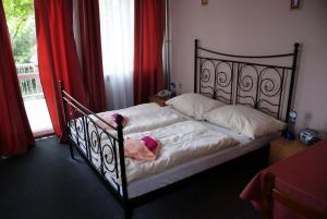 a bedroom with a bed with a doll on it at Pension Zlata Noha in Bratislava