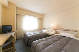 Tokushima Washington Hotel Plaza tesisinde bir odada yatak veya yataklar