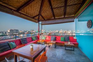 ein Restaurant mit Tischen und Stühlen und Stadtblick in der Unterkunft Ostello Bello Mandalay in Mandalay