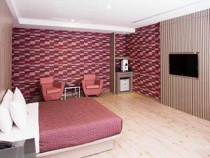 pokój hotelowy z łóżkiem i telewizorem w obiekcie Midi Motel Pingtung Branch w mieście Pingdong