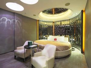 - une chambre avec un grand lit et deux chaises dans l'établissement Royal Group Motel Buo Ai Branch, à Kaohsiung